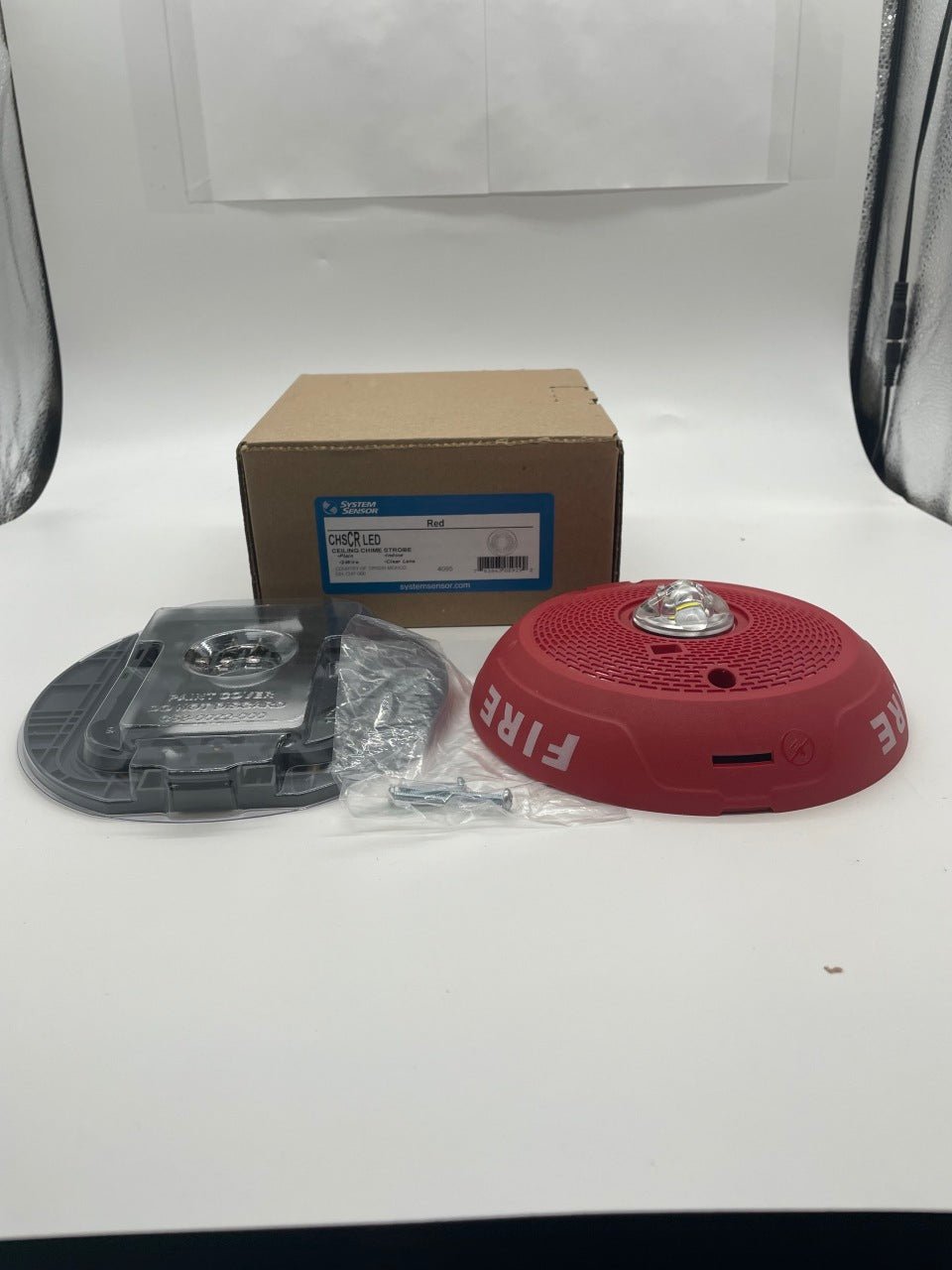 Red System Sensor CHSCRLED chime and strobe alarm with a sleek design, visible red strobe light and chime components.