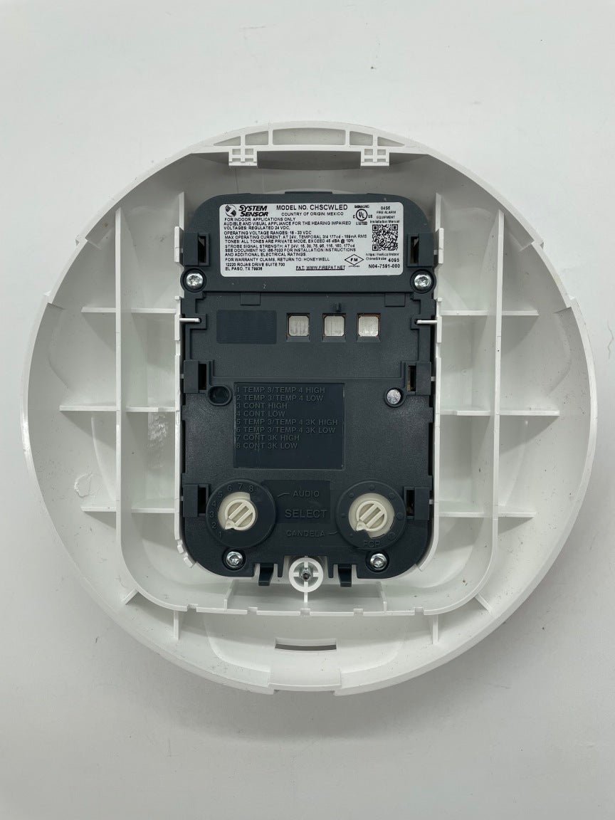 White System Sensor CHSCWLED chime strobe light mounted on wall, designed for fire alarm signaling and visual alerts.