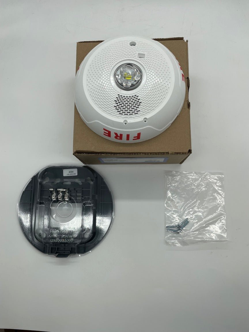 White System Sensor CHSCWLED chime strobe light with chimes, designed for fire alarm systems, mounted on a wall.