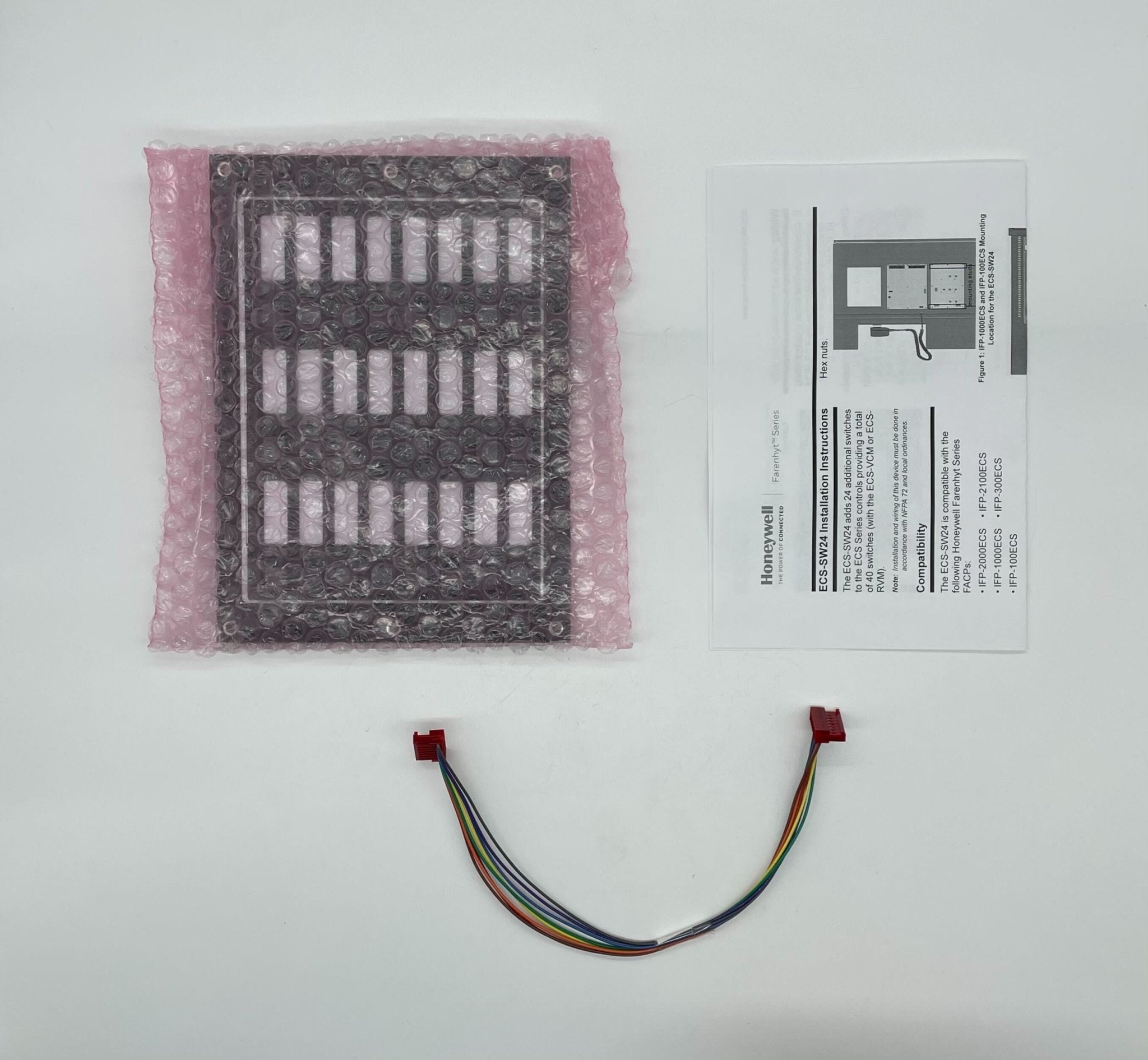 Silent Knight ECS-SW24 24-switch expander for fire alarm systems, mounted on a wall with visible wiring and controls.