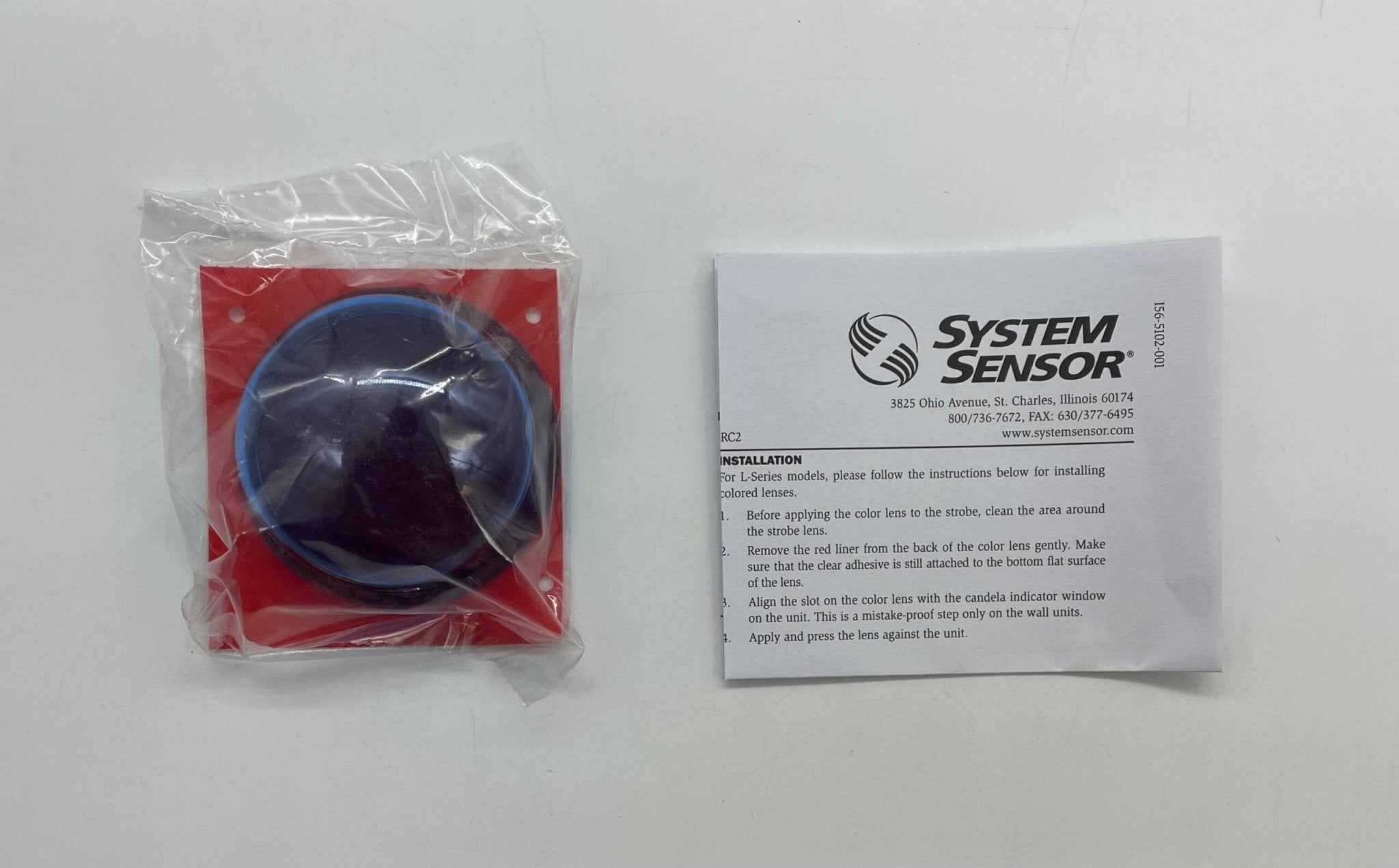 System Sensor LENS-BC2 fire alarm with lens cover, mounted on wall, showcasing its design and sensor features.