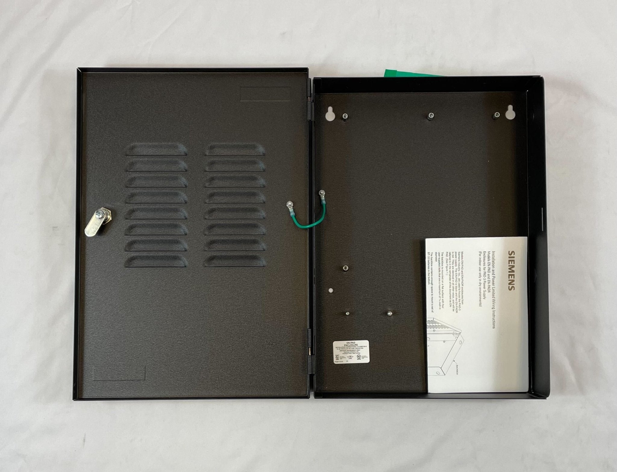 Black Siemens EN-PAD enclosure for PAD-3 fire alarm system, protective housing with secure mounting for safety and durability.